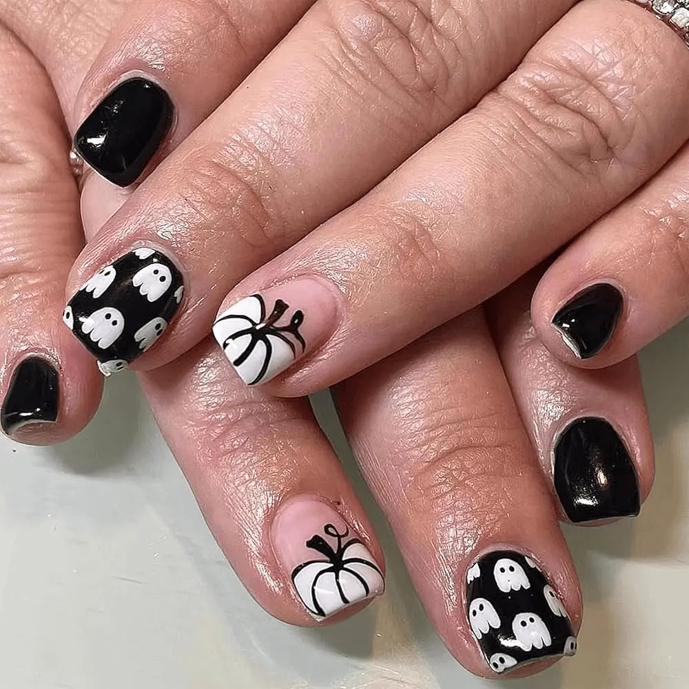 A Halloween nail art design featuring ghost and pumpkin.